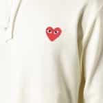Zoom sur logo en forme de coeur rouge avec yeux sur un vêtement blanc