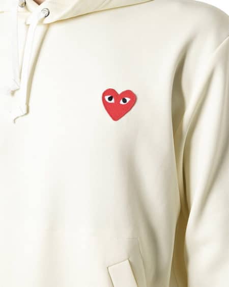 Zoom sur logo en forme de coeur rouge avec yeux sur un vêtement blanc
