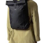 Homme portant un sac à dos noir et une veste jaune vue de dos