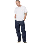 Homme portant un t-shirt à manches courtes blanc, un jean bleu foncé et des baskets blanches et vertes