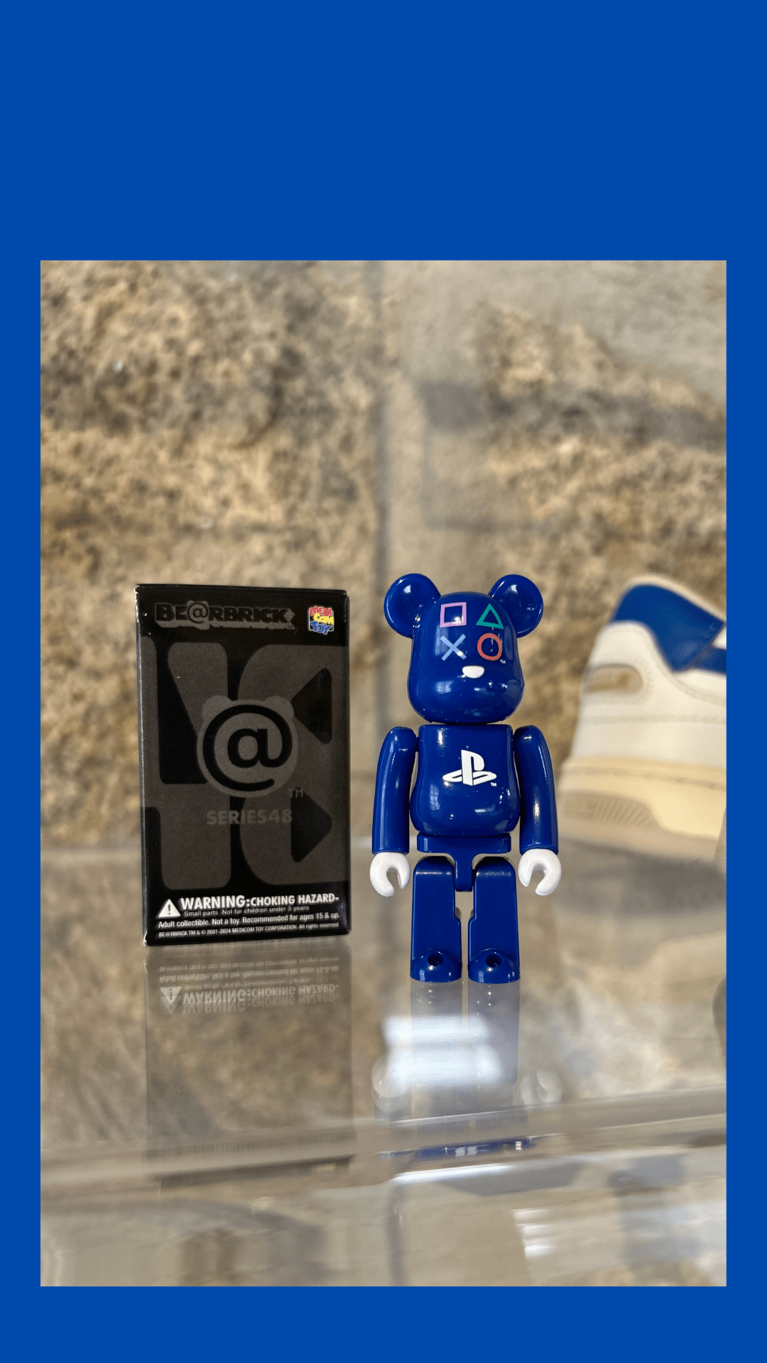 bearbrick serie 100% posé sur une étagère avec sa boite à coté