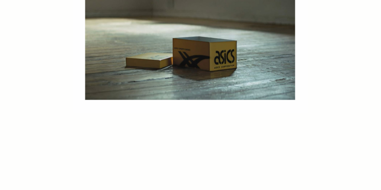 boite de sneakers de la marque asics posee sur un sol